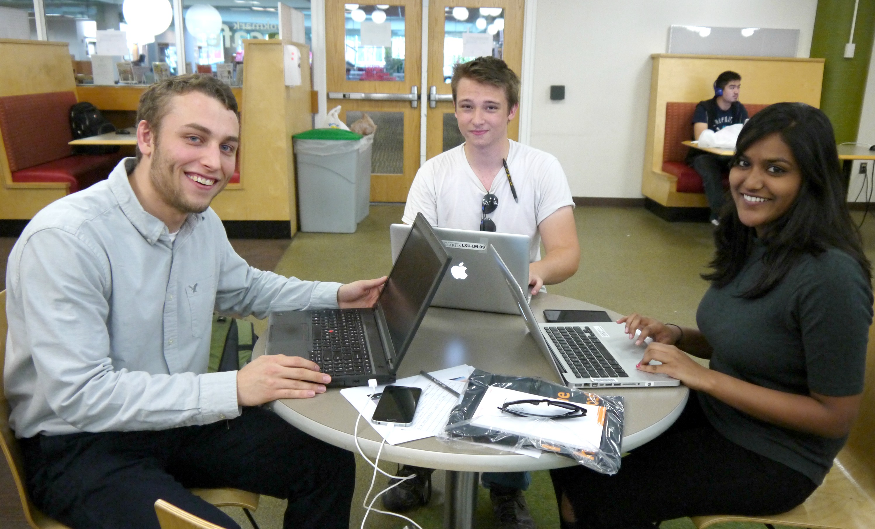 Three students work on laptops in the bookmark cafe